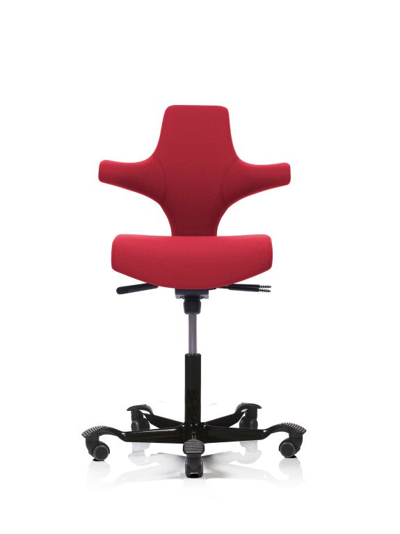 A red HÅG Capisco 8126 office chair with a short seat and down-turned front, on a black five-point chrome base with castors.