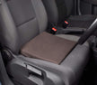 A black slimline wedge cushion placed on a car seat to demonstrate its use for posture support.