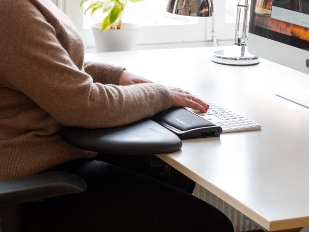 image showing mousetrapper symmetrical forearm support clamped on to the front of desk with person resting forearms on it