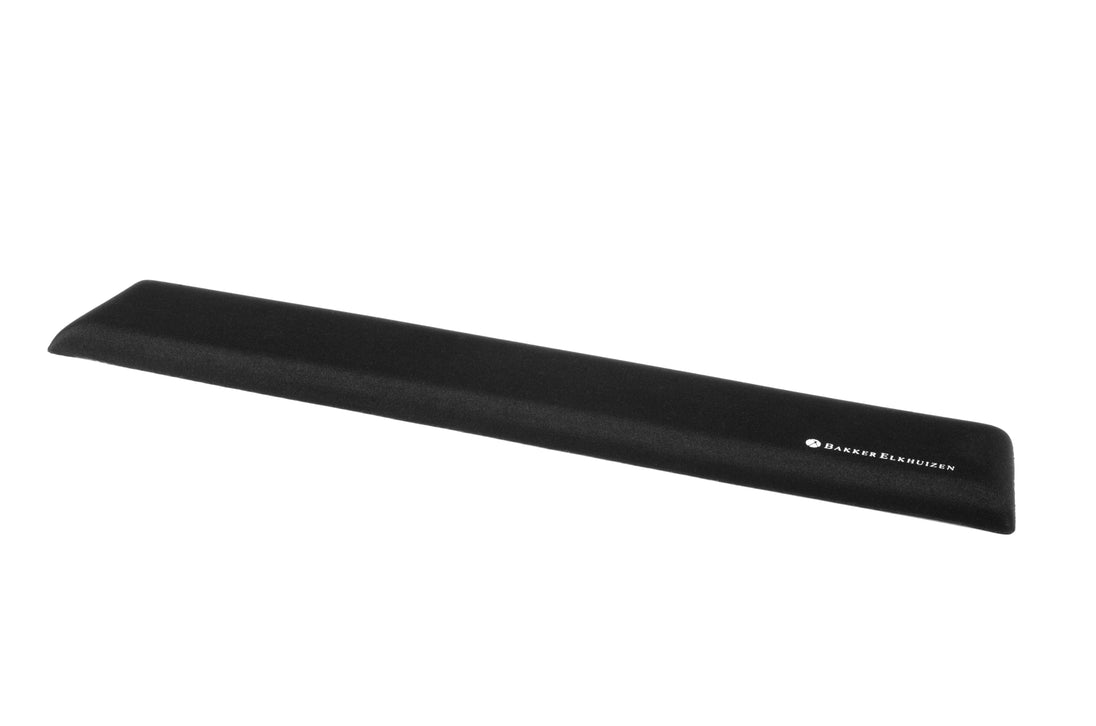 A black trapezium-shaped wrist rest designed for use with keyboards, featuring a soft surface and antibacterial technology.